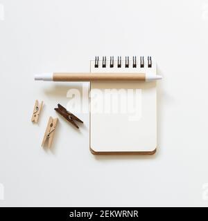 Empty notebook with pen, wooden clip on white background. top view, copy space Stock Photo