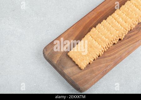 A wooden cutting board with delicious crackers Stock Photo