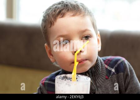 The child drinking milkshake in the cafe Stock Photo