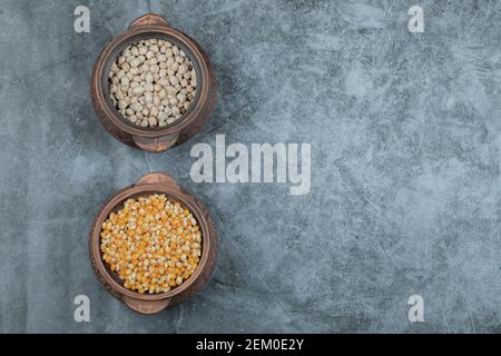 Two pots full of raw peas and popcorn Stock Photo