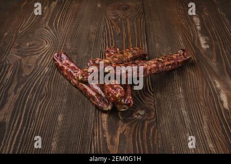 dried jerked deer and pork sausage on wooden background Stock Photo