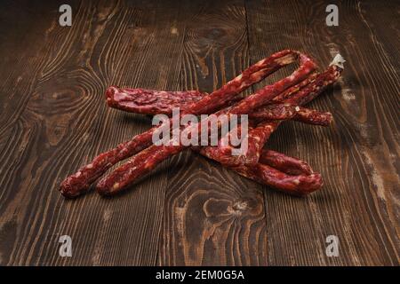 Air dried deer and pork sausage on wooden background Stock Photo