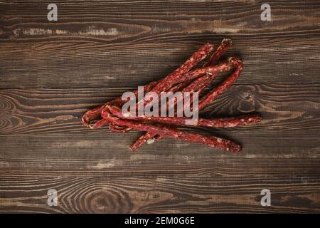 Overhead view of air dried deer and pork sausage on wooden background Stock Photo