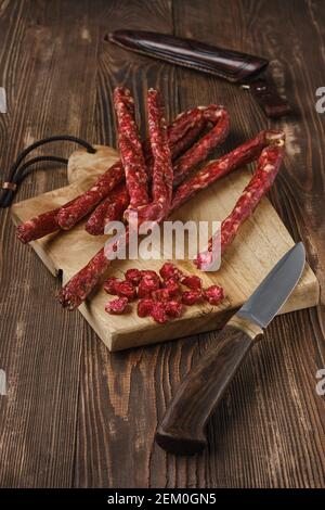 Air dried deer and pork sausage on wooden background Stock Photo