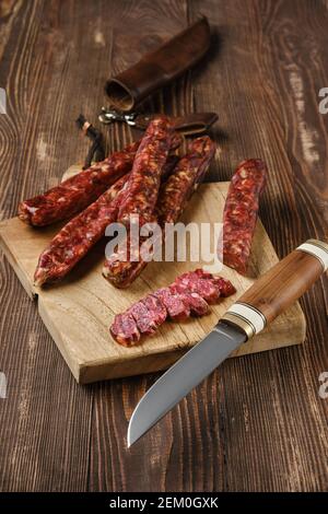 dried jerked deer and pork sausage on wooden background Stock Photo