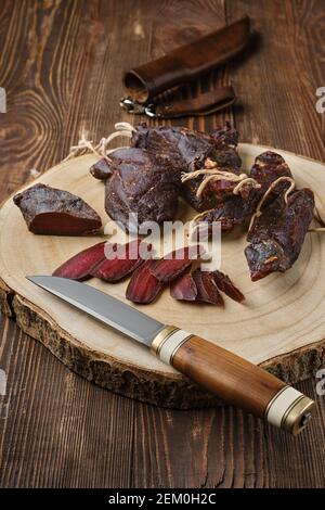 Overhead view of dried jerked deer or venison meat on wooden background Stock Photo