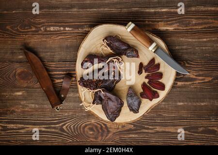 Overhead view of dried jerked deer or venison meat on wooden background Stock Photo