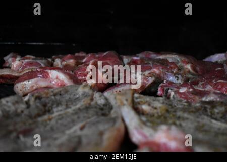 meat cooking on a gas powered barbeque at a home in Sydney, Australia with meat that is barely cooked yet on it. Stock Photo