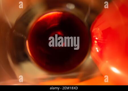 Red wine resembling the pupil of the eye on the bottom of a glass shot from above in motion blur patterns of refracted and distorted light and color Stock Photo