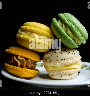 Colorful macarons stacked elegantly on a plate against a dark background showcasing intricate designs and vibrant colors Stock Photo