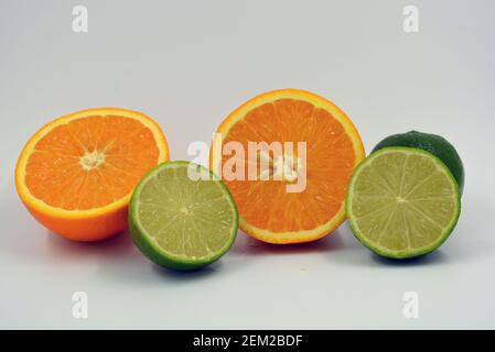 Healthy ripe delicious fruits for human health. Juicy fruits of orange orange, lime with bright green mint. Two halves of an orange, two halves. Stock Photo