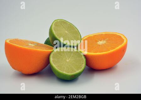 Healthy ripe delicious fruits for human health. Juicy fruits of orange orange, lime with bright green mint. Two halves of an orange, two halves. Stock Photo