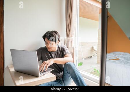 handsome asian modern man designer working home using laptop at home Stock Photo