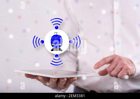 Smart train concept above a tablet held by a man in background Stock Photo