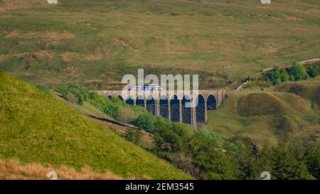 Near Cowgill, Cumbria, England, UK - May 16, 2019: A train passing the Arten Gill Viaduct on the Settle-Carlisle Railway line