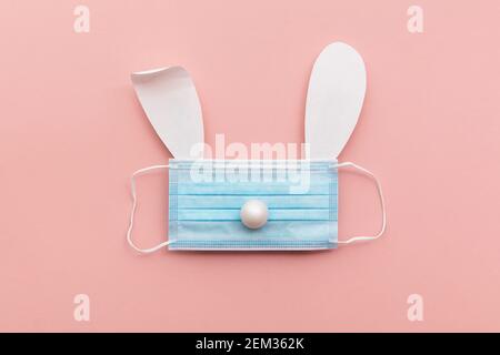 Coronavirus Easter bunny face made from rabbit ears and a protective face mask Stock Photo