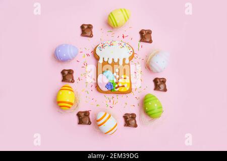 Easter cake, eggs, sugar sprinkles and chocolate bunny on a pink background. Sweets for celebrating Easter. Stock Photo