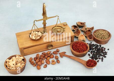 Chinese herbs and spice used in traditional herbal medicine with old apothecary brass weighing scales. Alternative health care concept. Stock Photo