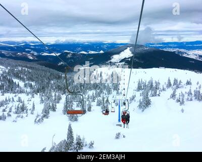 People on a ski lift over the Carpathians mountains. Dragobrat, Ukraine Stock Photo