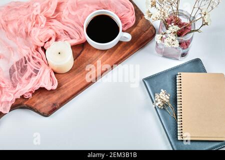 Notebooks and cup of coffee on the wooden board with flowers Stock Photo