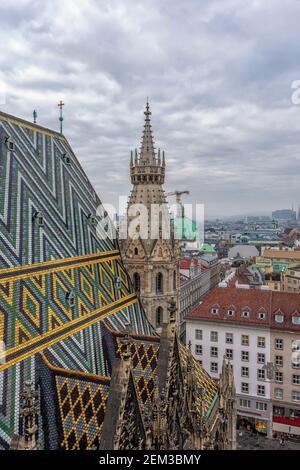 Aerial view over the rooftops of Vienna city from the north tower of St. Stephen's Cathedral with the cathedral's famous ornately patterned roof. Stock Photo