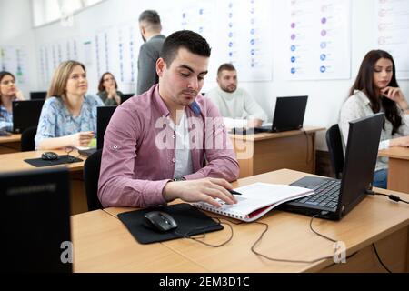 Young man sitting in the class studying his notes, student concept Stock Photo
