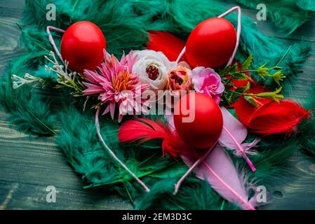 Easter eggs. Colored egg. Easter. Red eggs on green feathers Stock Photo
