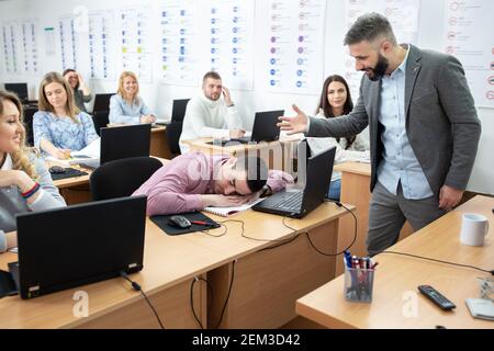Tired student sleeping in the middle of a class, student concept Stock Photo