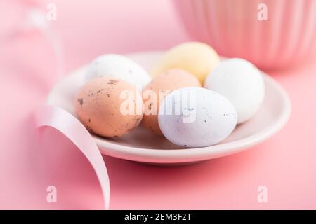 Colorful chocolate easter eggs. Sweet candy eggs on a pink background. Stock Photo