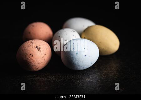 Colorful chocolate easter eggs. Sweet candy eggs on a black table. Stock Photo