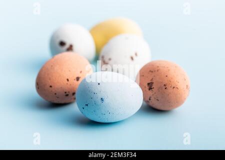 Colorful chocolate easter eggs. Sweet candy eggs on a blue background. Stock Photo
