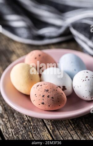 Colorful chocolate easter eggs. Sweet candy eggs on a wooden table. Stock Photo