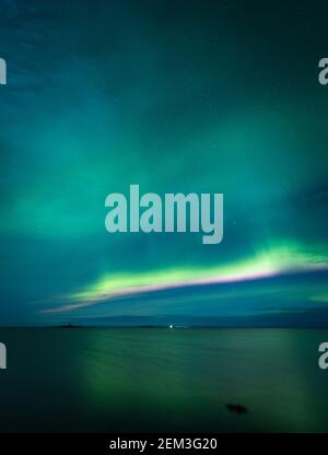 Aurora Borealis on the night sky above the sea. Winter night in Norway. Pure Northern nature. Stock Photo