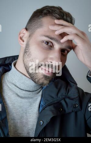Portrait of a young man touching his forehead in a moment of inspiration Stock Photo