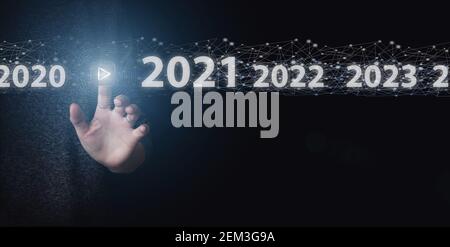 Hand Holding Digital Polygonal Wireframe Hologram Over Dark Background,Luminous 2020 year numbers and network above hand at black background. New 2020 Stock Photo