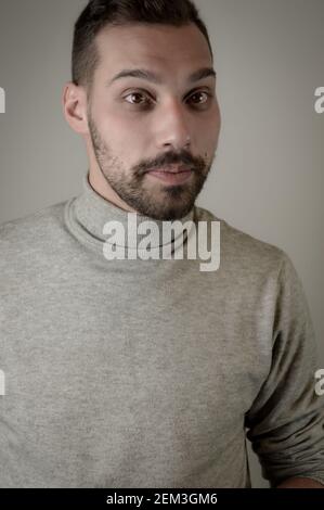 Portrait of a young man with a short beard that looks surprised Stock Photo