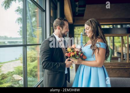 Happy couple standing in cafe opposite each other Stock Photo