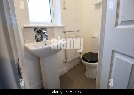 A brand new modern British home showing a new UK style bathroom, toilet and bathroom sink basin Stock Photo