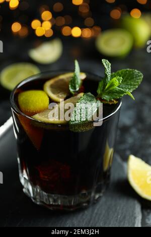 Glass of Cuba Libre cocktail against blurred lights, close up Stock Photo