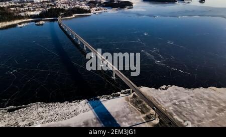 Top down view of a highway bridge spanning over a frozen lake. Stock Photo