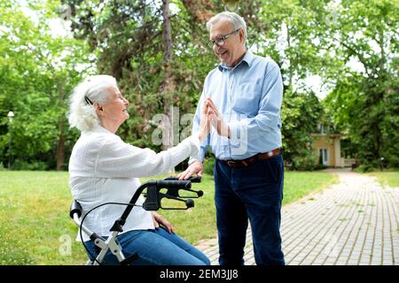 Senior couple in the park taking a break for a moment from walking Stock Photo