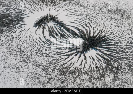 Magnetic field lines concept with bar magnet attraction and repulsion iron particles along lines of force Stock Photo