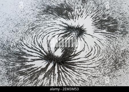 Magnetic field lines concept with bar magnet attraction and repulsion iron particles along lines of force Stock Photo