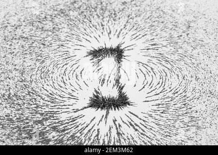 Magnetic field lines concept with bar magnet attraction and repulsion iron particles along lines of force Stock Photo