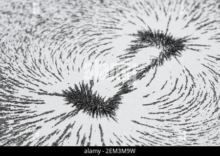 Magnetic field lines concept with bar magnet attraction and repulsion iron particles along lines of force Stock Photo