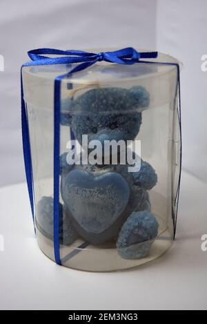 Beautiful blue candle in the form of a teddy bear, handmade on a white background. Stock Photo