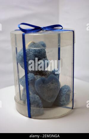 Beautiful blue candle in the form of a teddy bear, handmade on a white background. Stock Photo