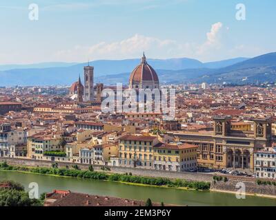 Cityscape of Florence. Cathedral of Santa Maria del Fiore with red-tiled dome, Giotto Bell Tower. National Library on the left side of the Arno river. Stock Photo