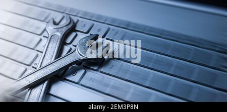 computer repair service - wrenches on laptop keyboard. copy space Stock Photo