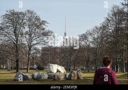 Berlin, Germany. 24th Feb, 2021. A person walks past the sculpture group (Global Stone Project) in the Tiergarten. The Berlin TV Tower can be seen in the background. Credit: Kira Hofmann/dpa-Zentralbild/dpa/Alamy Live News Stock Photo